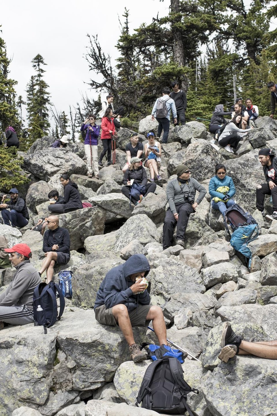 Plusieurs touristes assis sur des rochers dans le parc britanno-colombien de Joffre Lakes.
