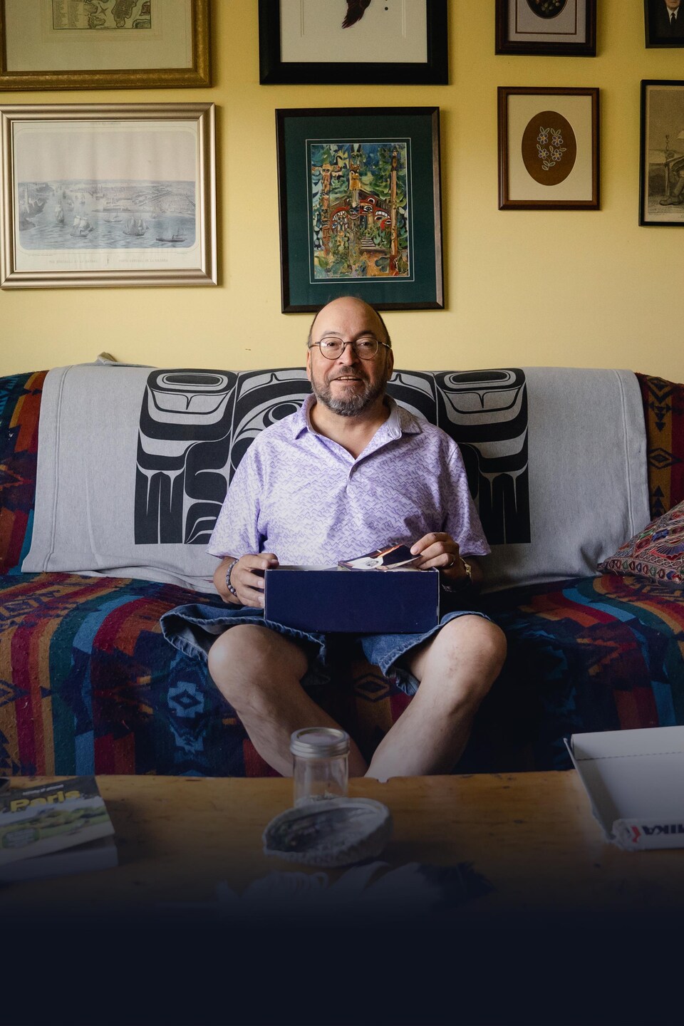 John Fingland est assis sur un divan dans sa maison, à Champagne, un hameau autochtone au Yukon, en août 2026.