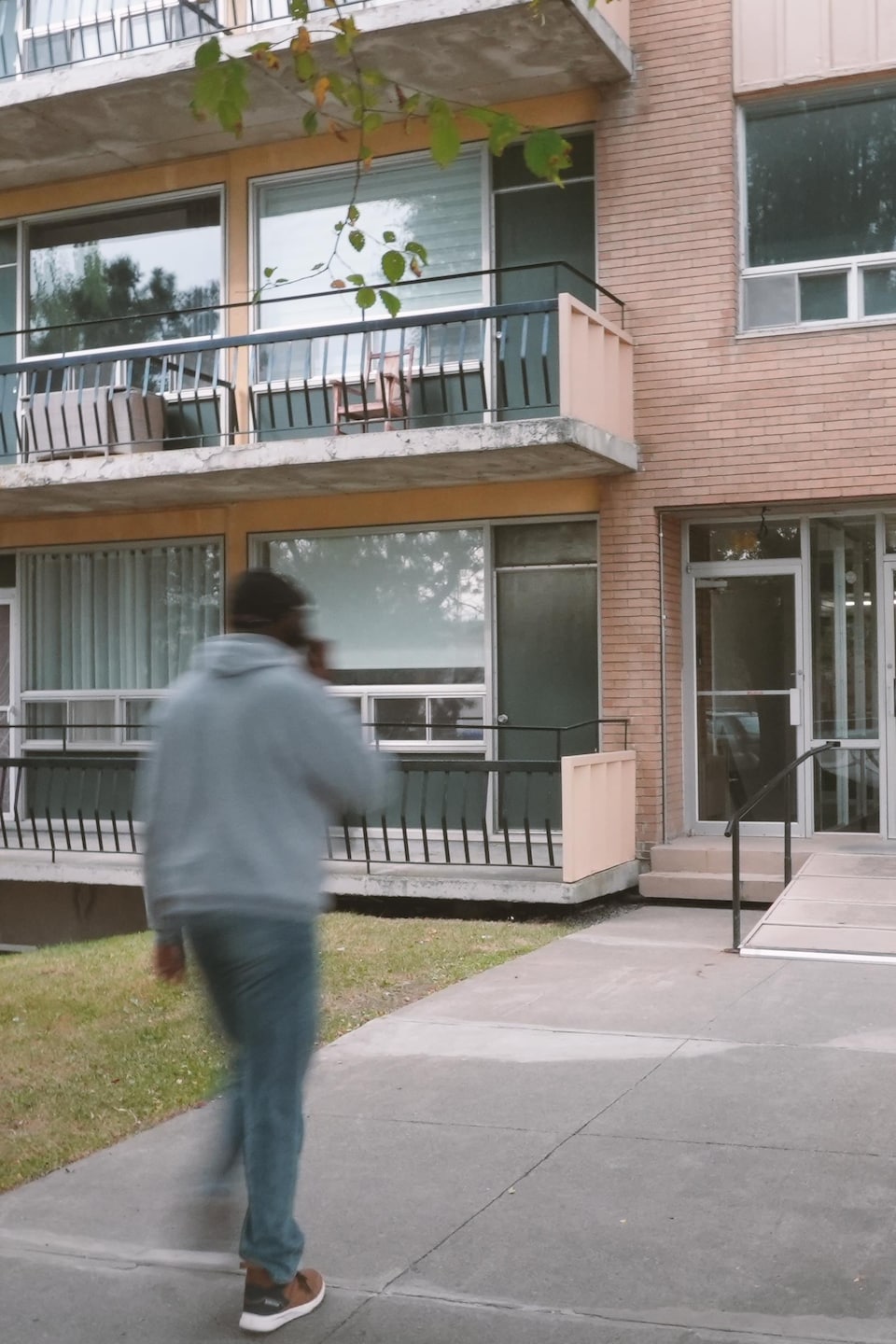 Un homme entre dans un immeuble à logements.