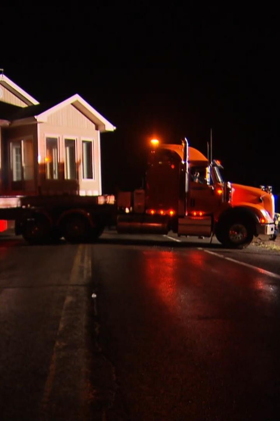 Une maison est déplacée en pleine nuit sur un camion.