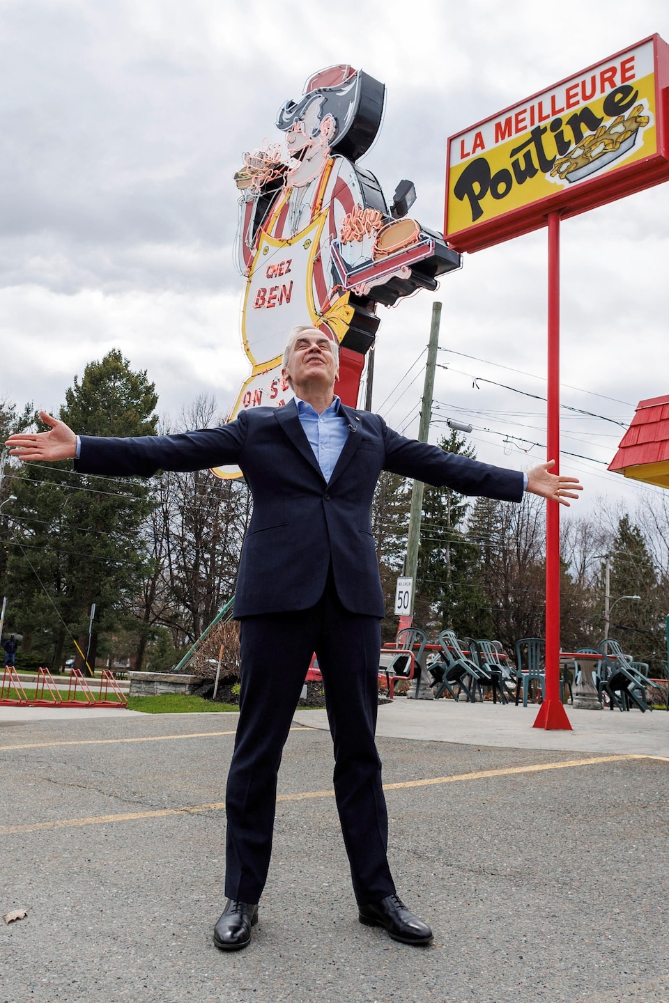 Mark Carney ouvre expansive  les bras dans le stationnement du restaurant.