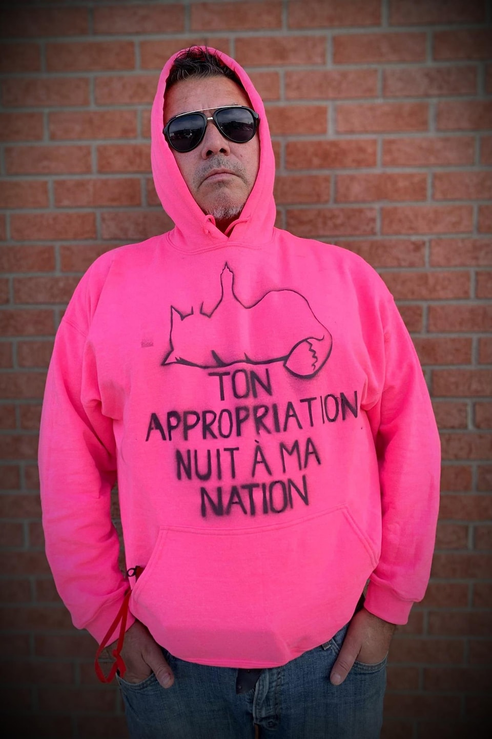 Jacques T. Watso porte un chandail sur lequel il est écrit : Ton appropriation nuit à ma nation.