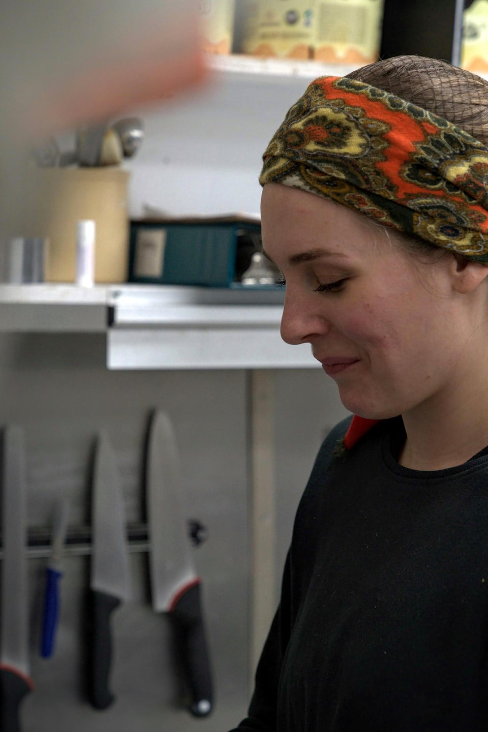 Une femme de côté dans une cuisine de restaurant.