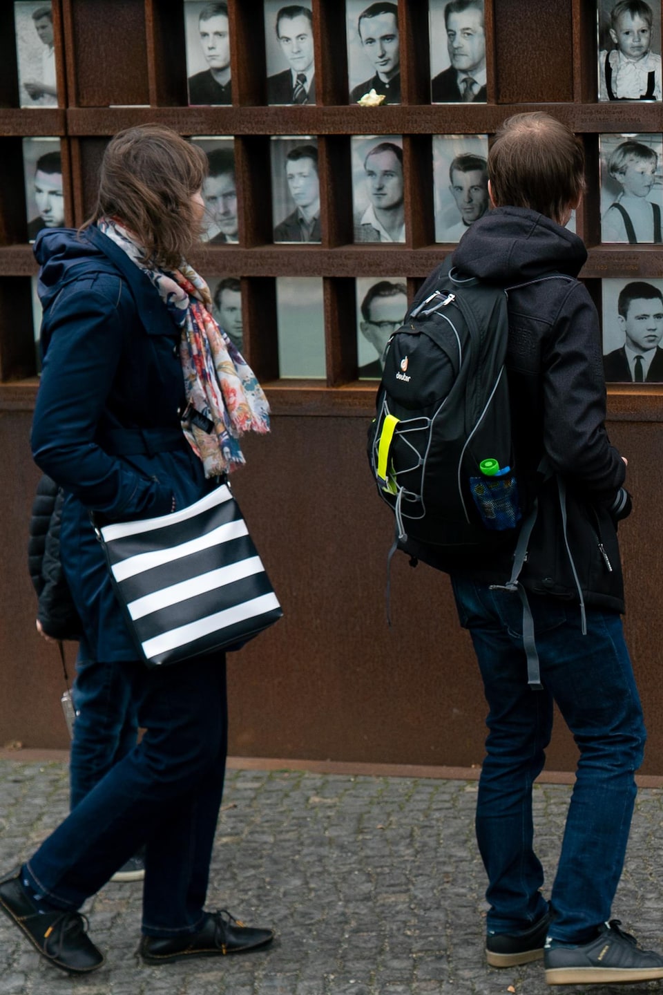 Des gens regardent les photos des victimes exposées au mémorial du mur de Berlin, situé sur Bernauer Strasse.