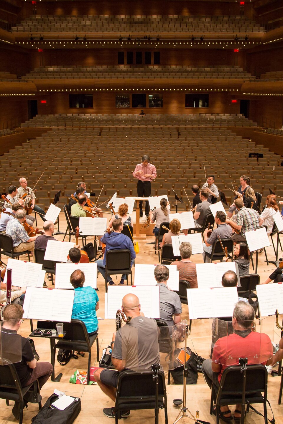Une vue en plongée des musiciens de l'OSM en répétition, avec le chef d'orchestre Kent Nagano.