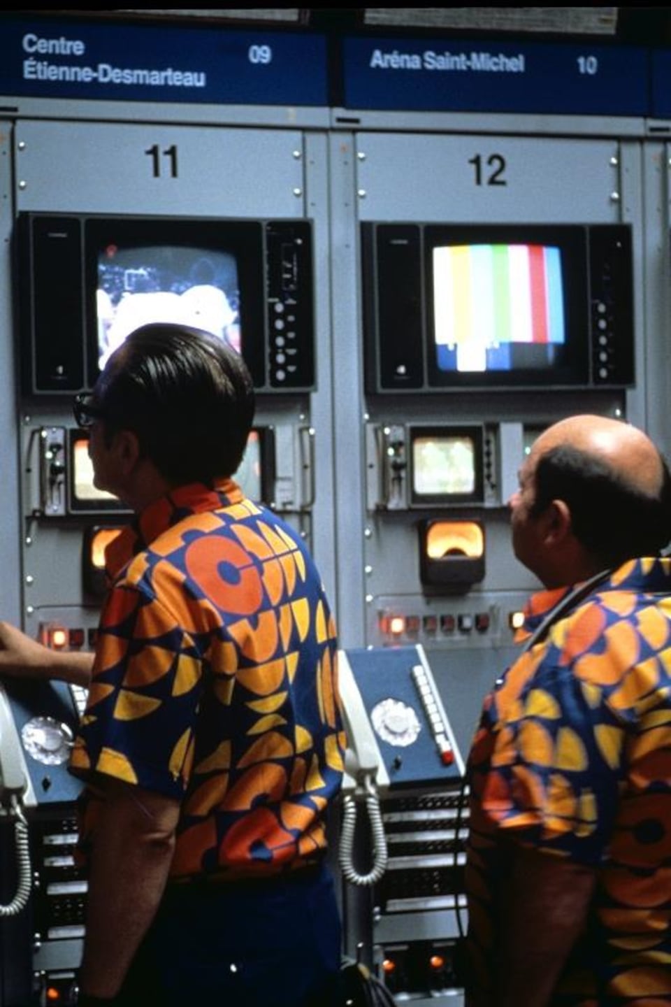 Deux techniciens portant la chemise officielle de l'ORTO regardent des moniteurs dans le centre de régie technique.