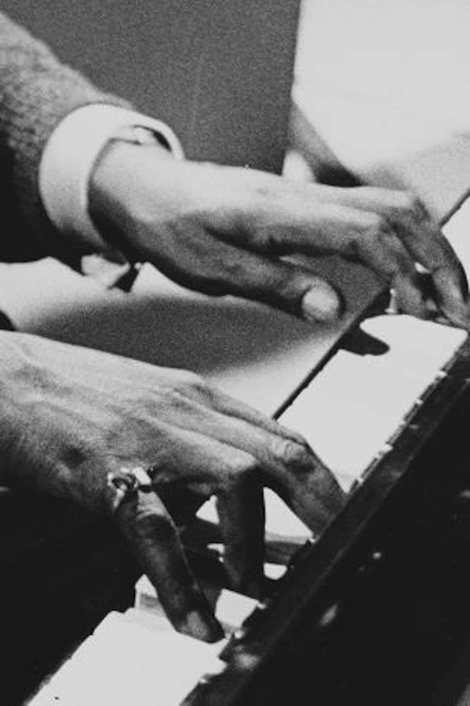 Dans un studio de télévision, Oscar Peterson en train de jouer du piano.