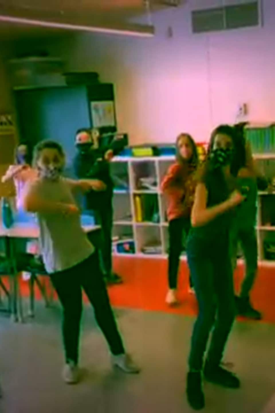 Des élèves dansent dans une classe.