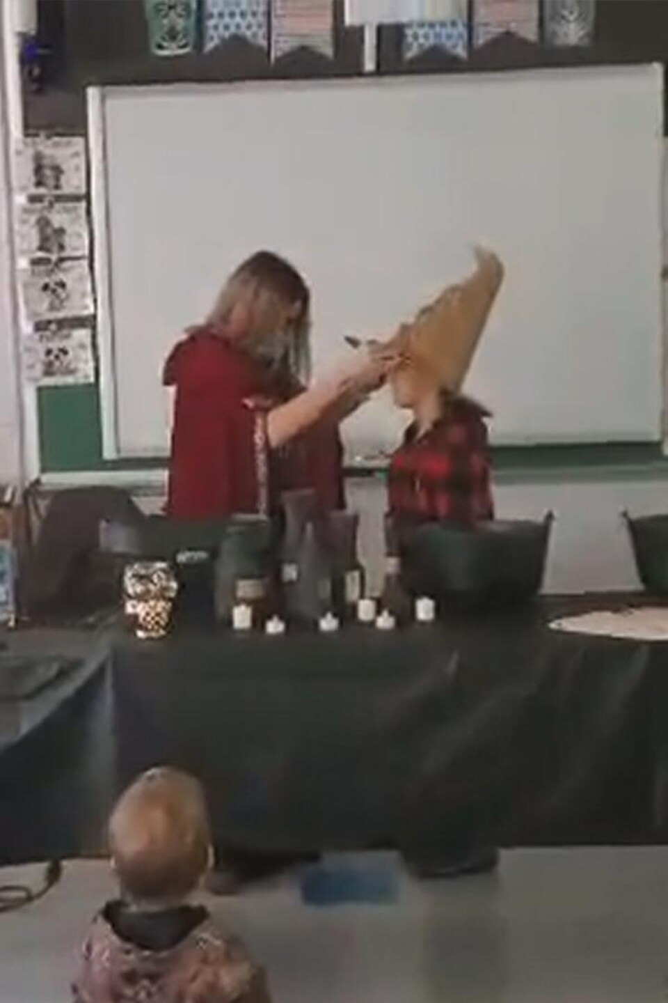 Une enseignante et un élève déguisés en sorciers.
