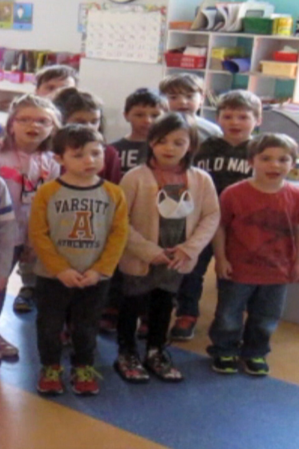 Des enfants chantent avec leur professeur.