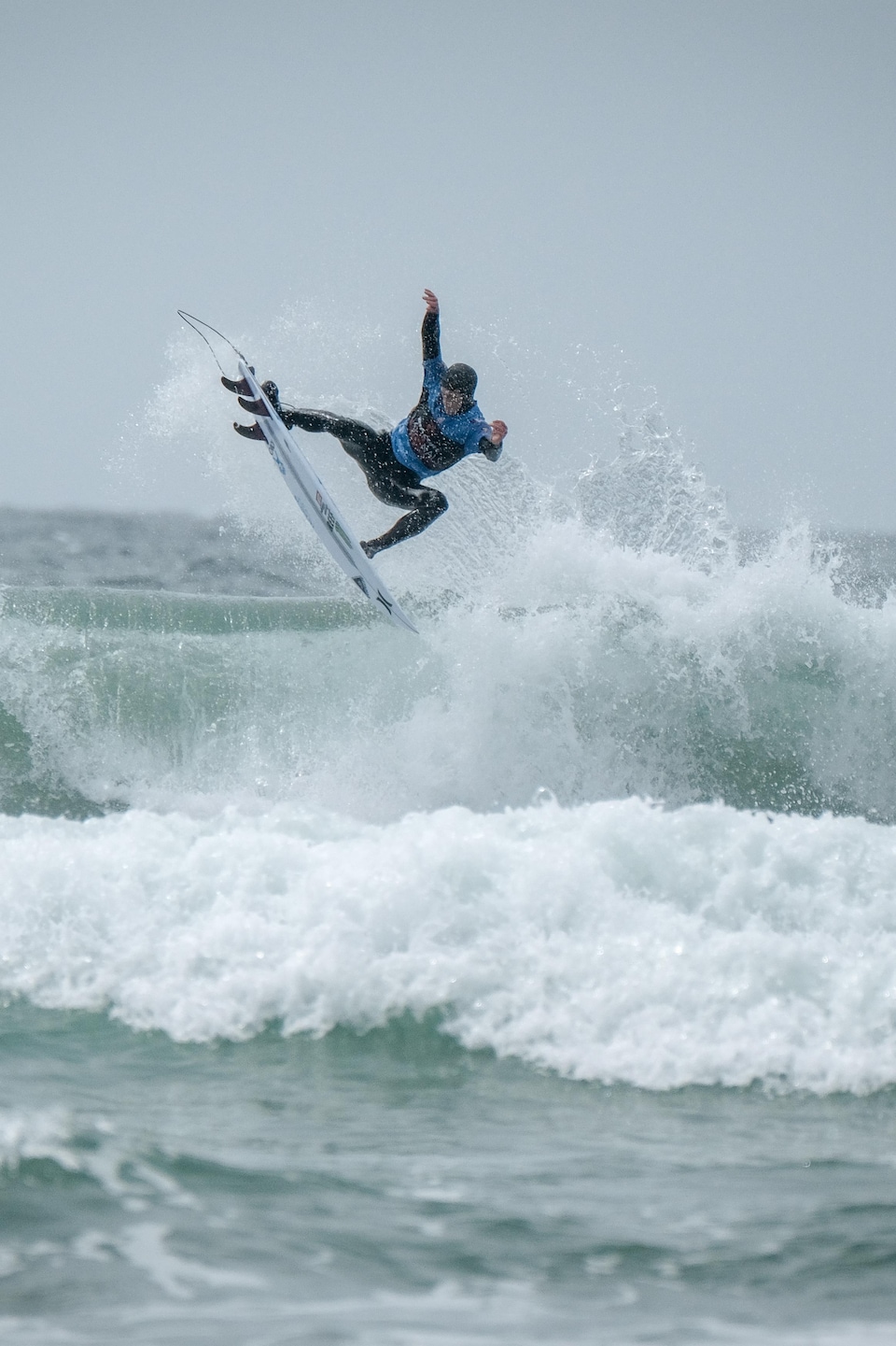 Peter Devries, champion canadien de surf 2019, est debout sur sa planche en haut d'une vague qui se brise à Tofino.
