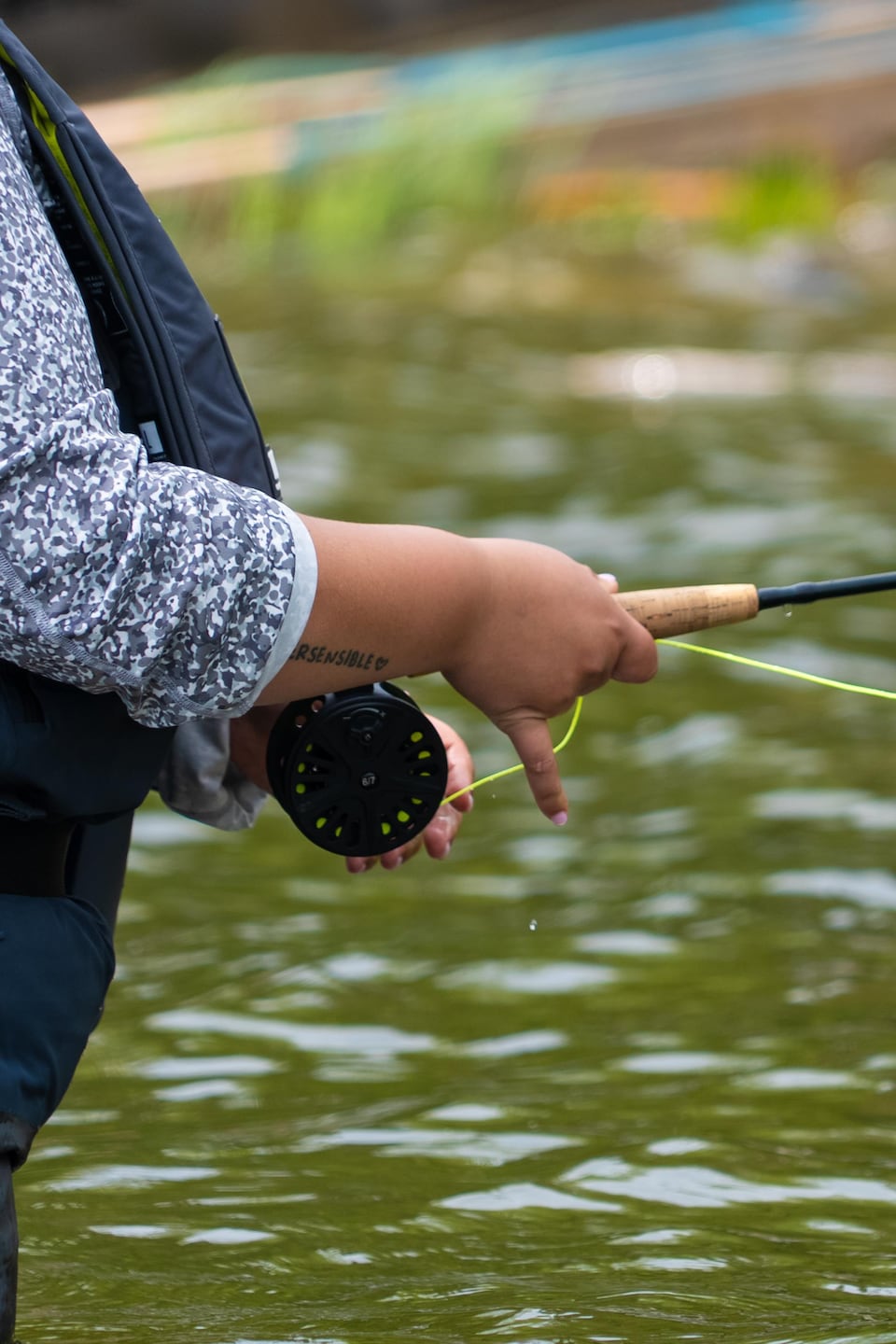 Une femme tient une canne à pêche.