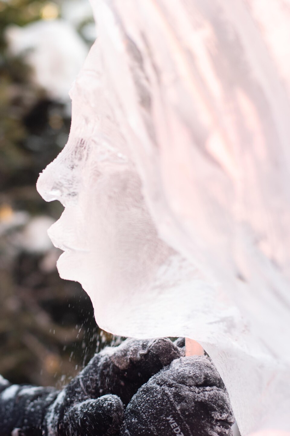 La sculpteuse se tient, de profil, face au visage de l'ange qu'elle sculpte.