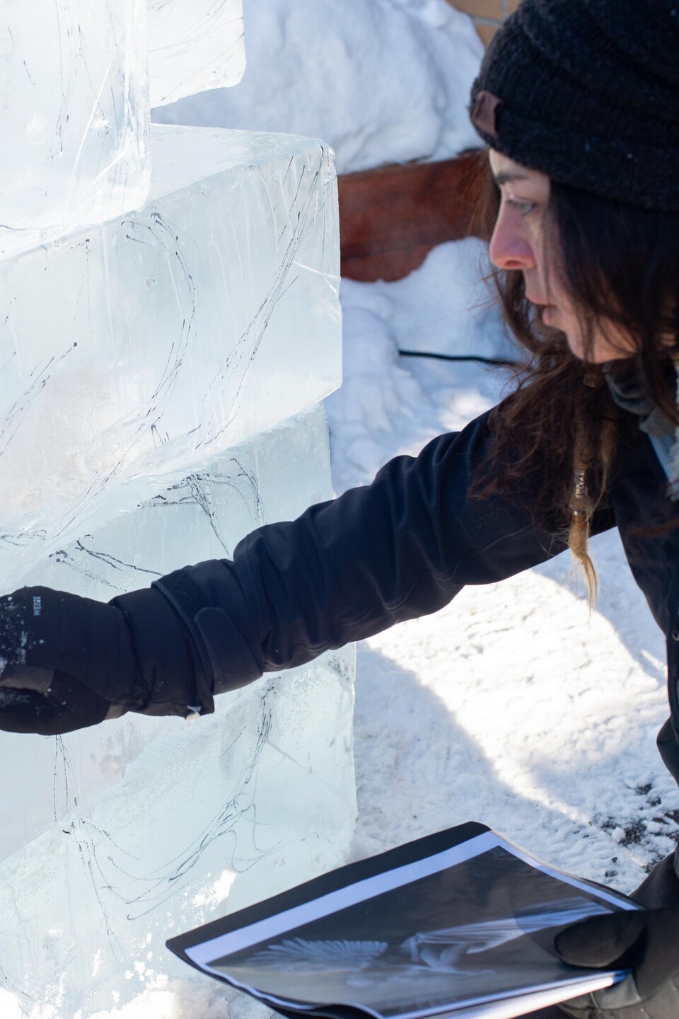 L'artiste trace au marqueur noir les formes de l'angle sur la glace, en guise de repères.