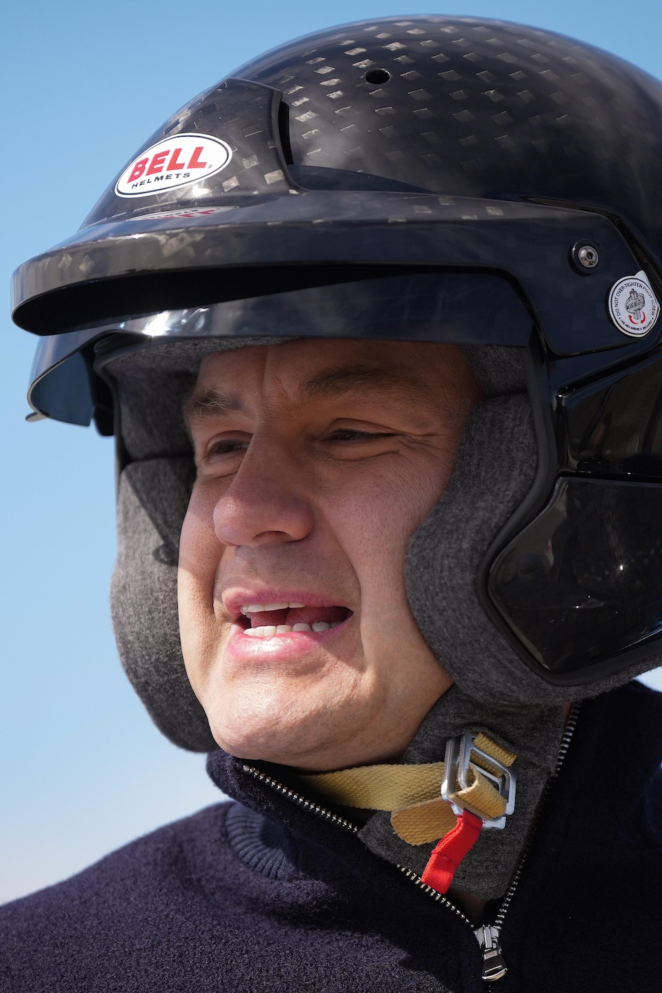 Pierre Poilievre porte un casque de extortion  noir et fait une moue. 