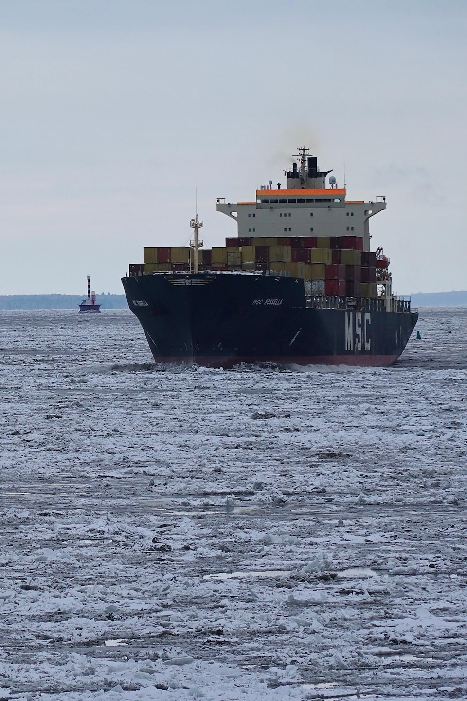 Un porte-conteneurs navigue à travers les glaces sur le fleuve Saint-Laurent.