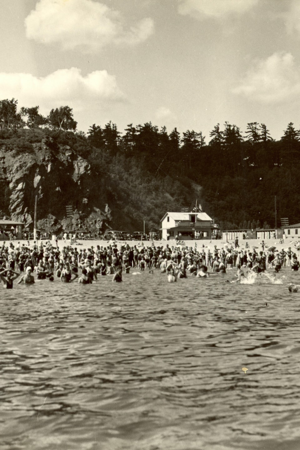 Le plaisir de se baigner dans le fleuve entre Québec et Sillery en 1938. La foule est nombreuse, il y a plus de gens dans l'eau que sur la plage, et il fait clairement très chaud.