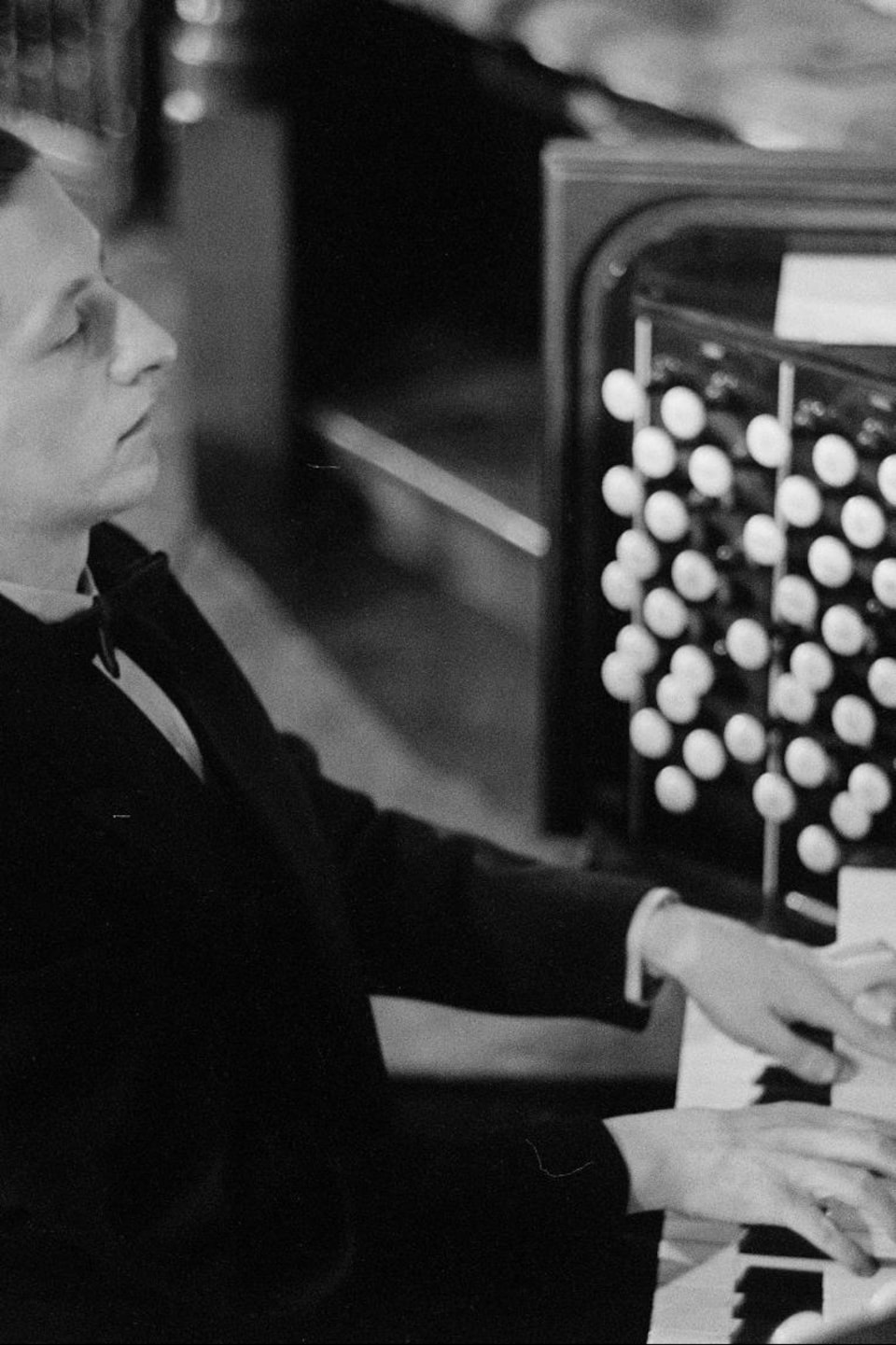 Raymond Daveluy pianotant sur l'orgue, les yeux fermés.