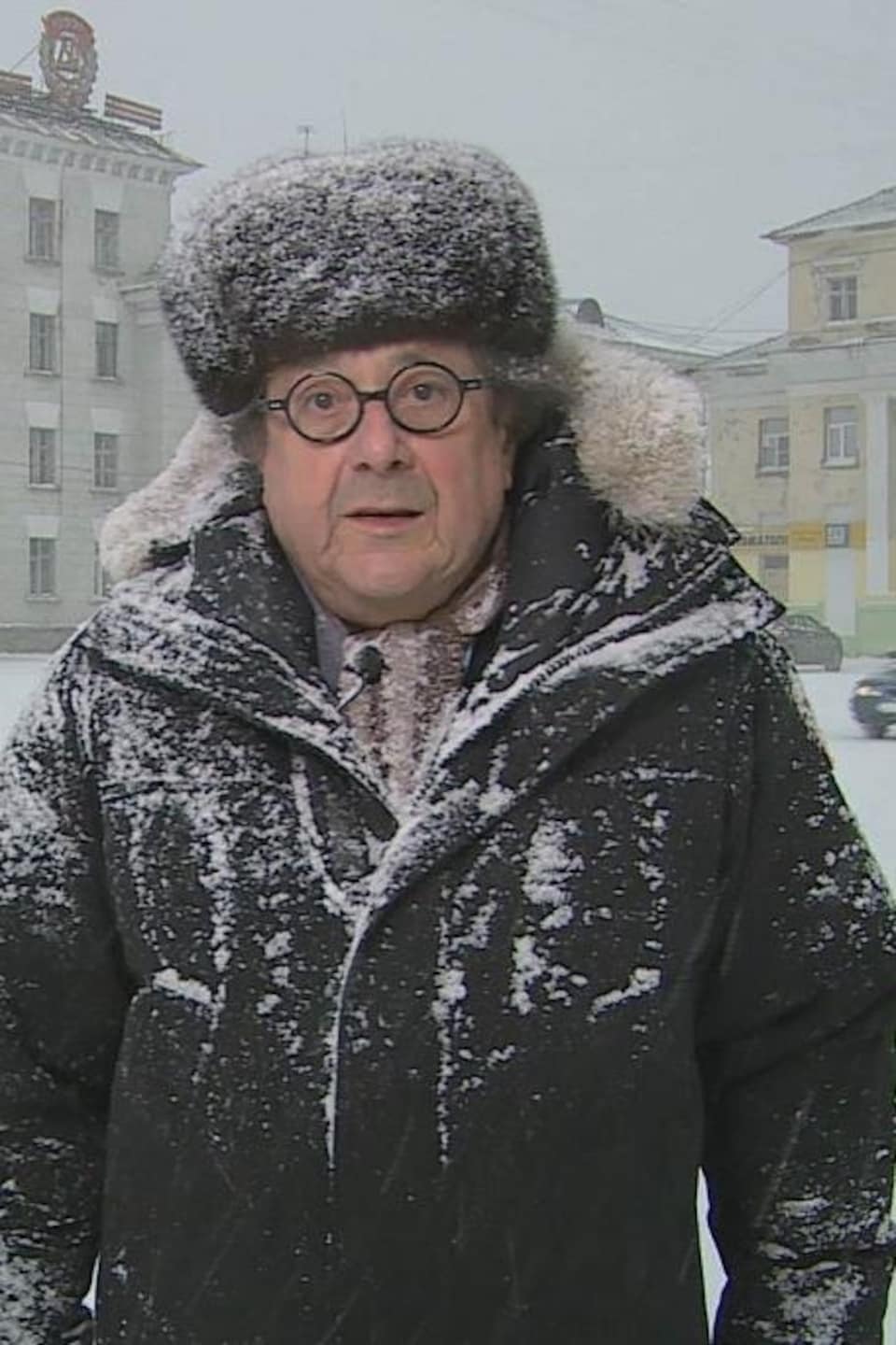 Le journaliste Raymond Saint-Pierre, correspondant à Moscou, sous la neige, devant un édifice.
