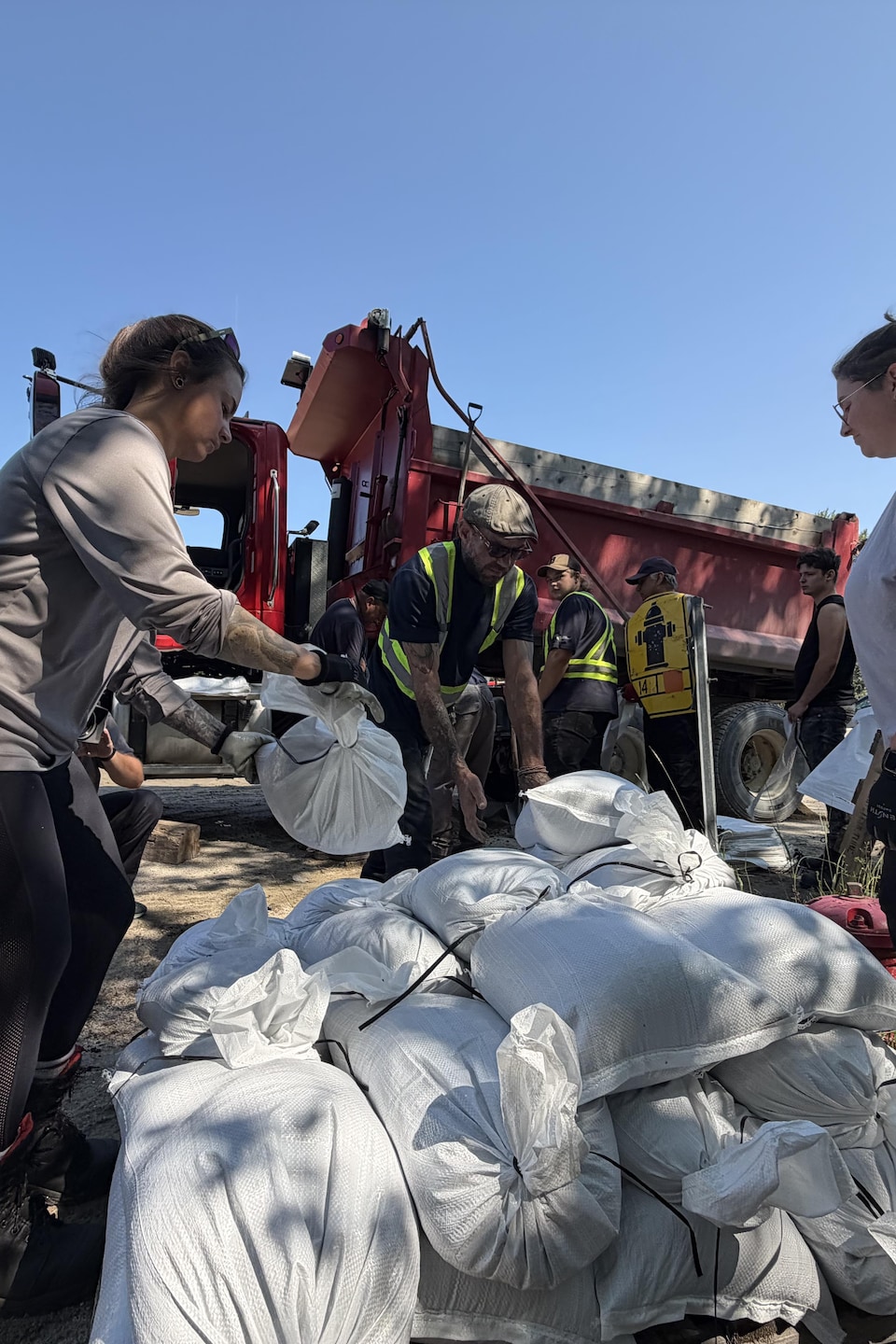 Des employés municipaux empilent des poches de sable.