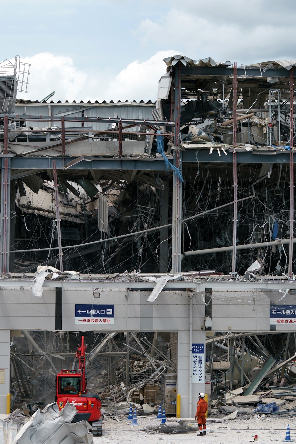 Des secouristes devant les ruines d'un édifice de plusieurs étages.
