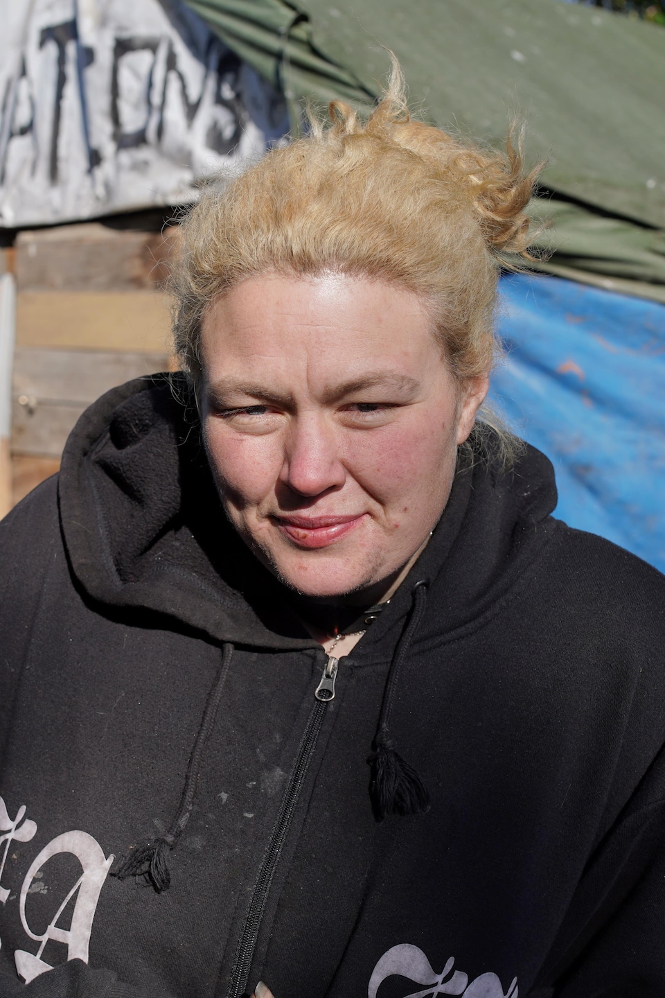 Sheena Derdak pose devant une cabane lors d'une journée ensoleillée, au parc Crab, à Vancouver, en octobre 2023.