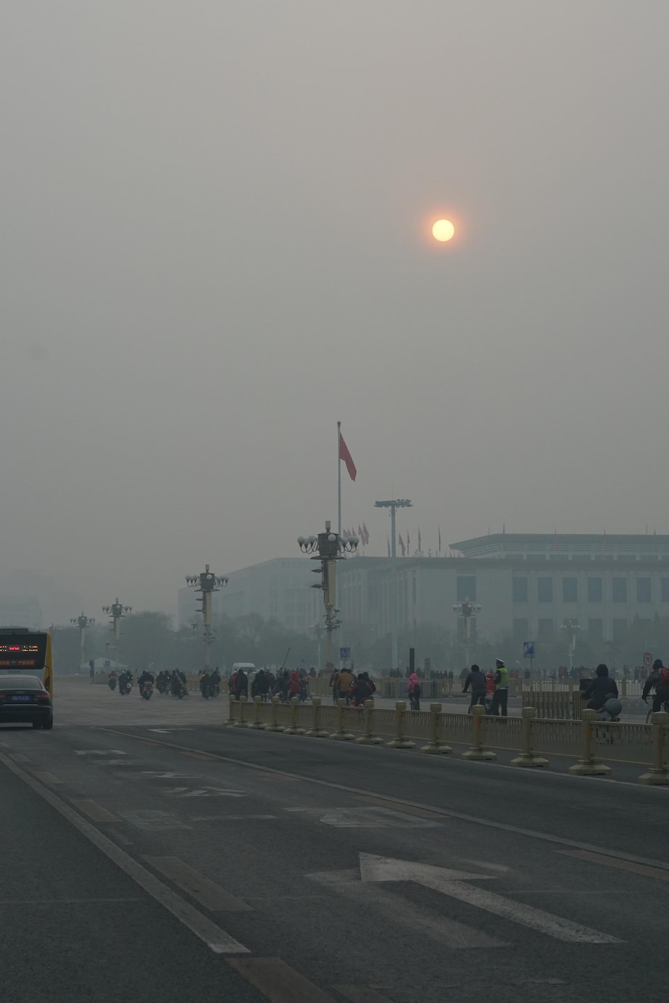 Une rue de Pékin sous le smog et un soleil obscurci.