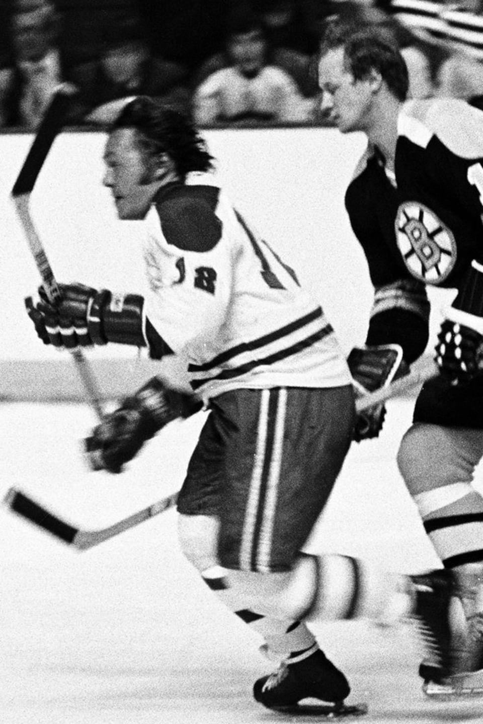 Le joueur Yvan Cournoyer sur la glace du Forum avec Wayne Cashmen des Bruins de Boston à sa poursuite.