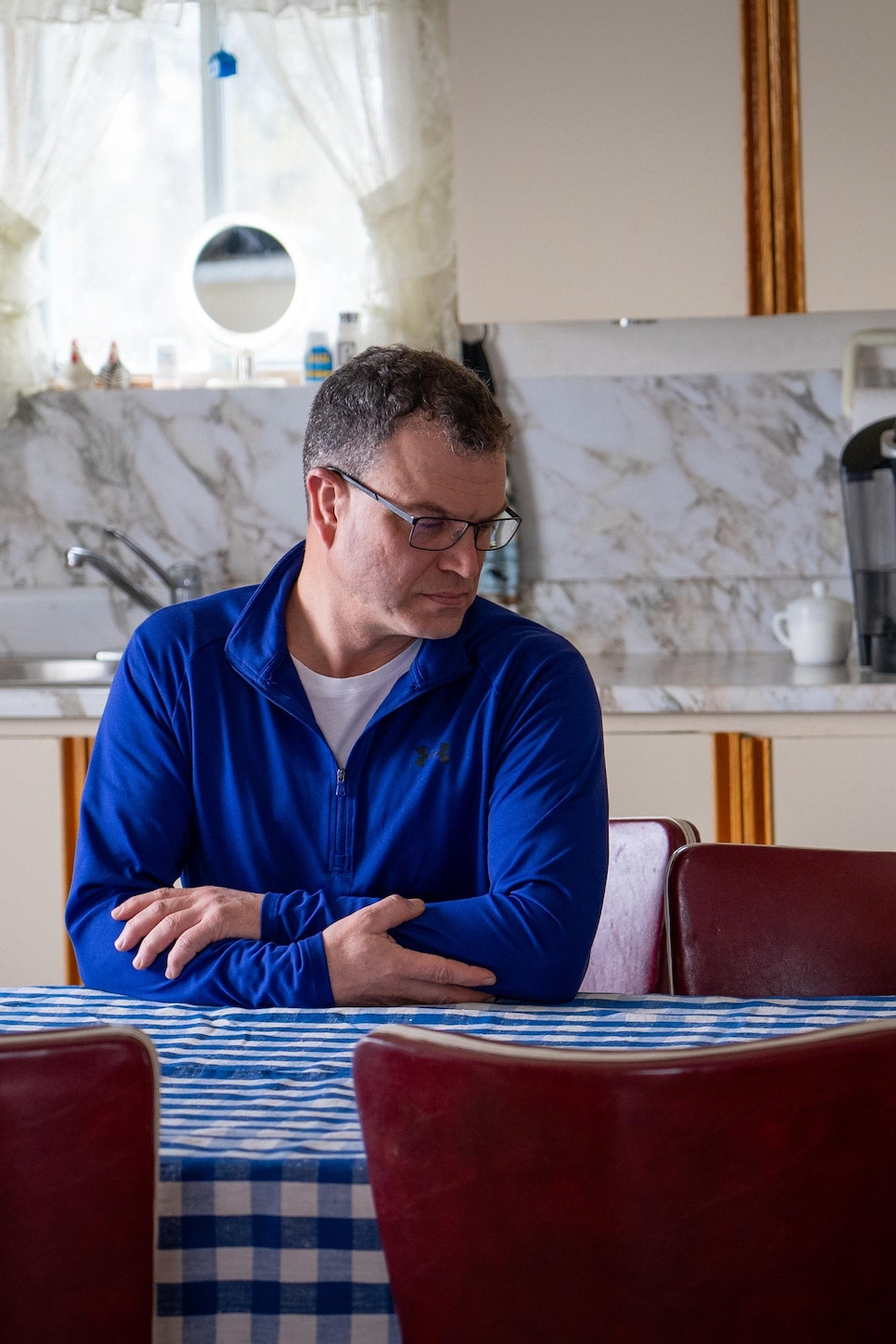 Sylvain Dufour regarde une chaise vide dans la cuisine de sa mère.