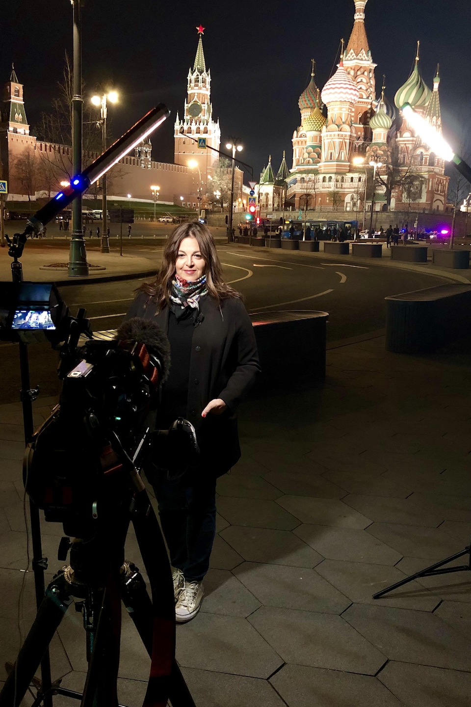 Tamara Alteresco posant devant la cathédrale Saint-Basile-le-Bienheureux de Moscou. La caméra et les dispositifs d'éclairage sont visibles dans le champ.