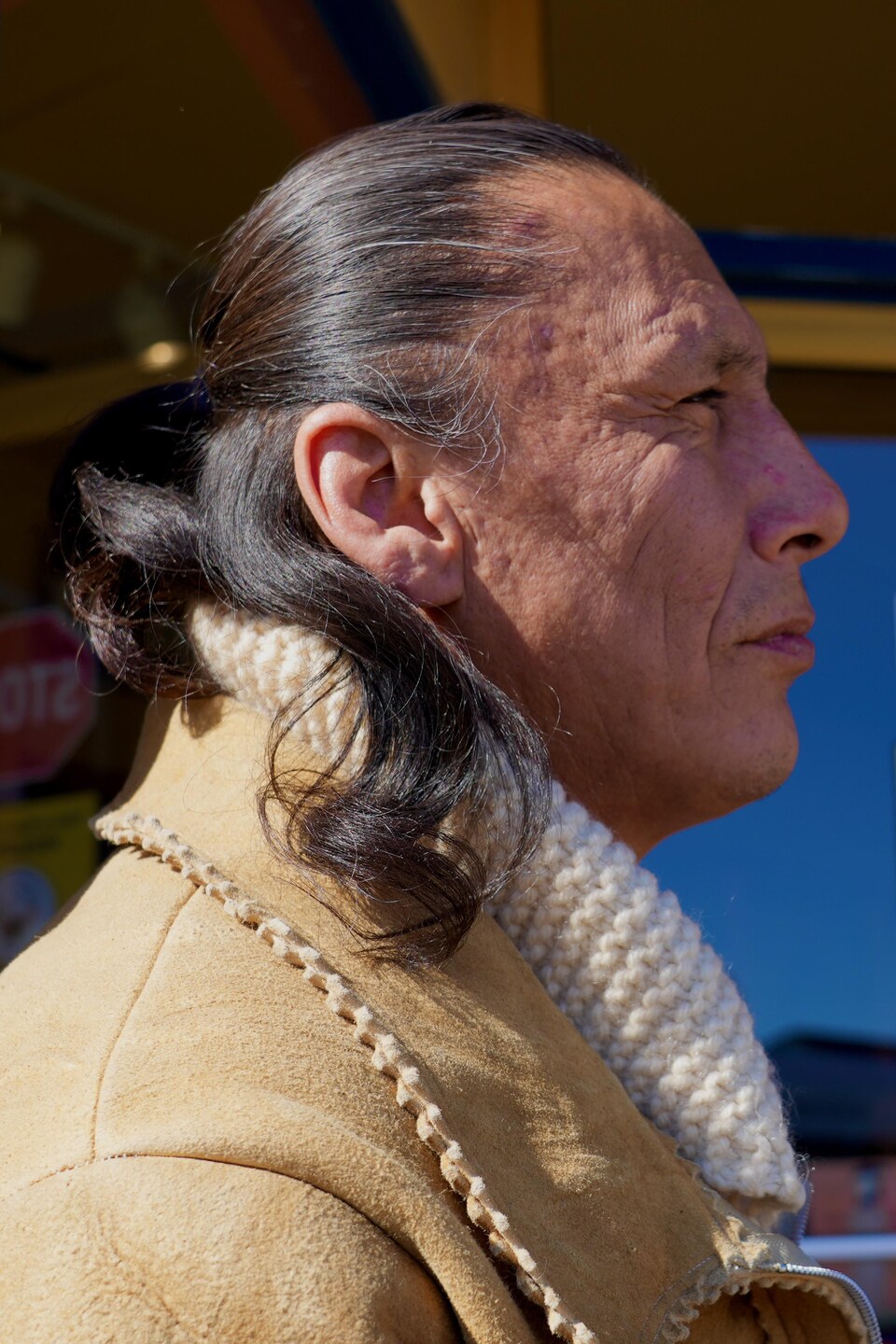 Un Autochtone est devant l'entrée d'un commerce de Thunder Bay.