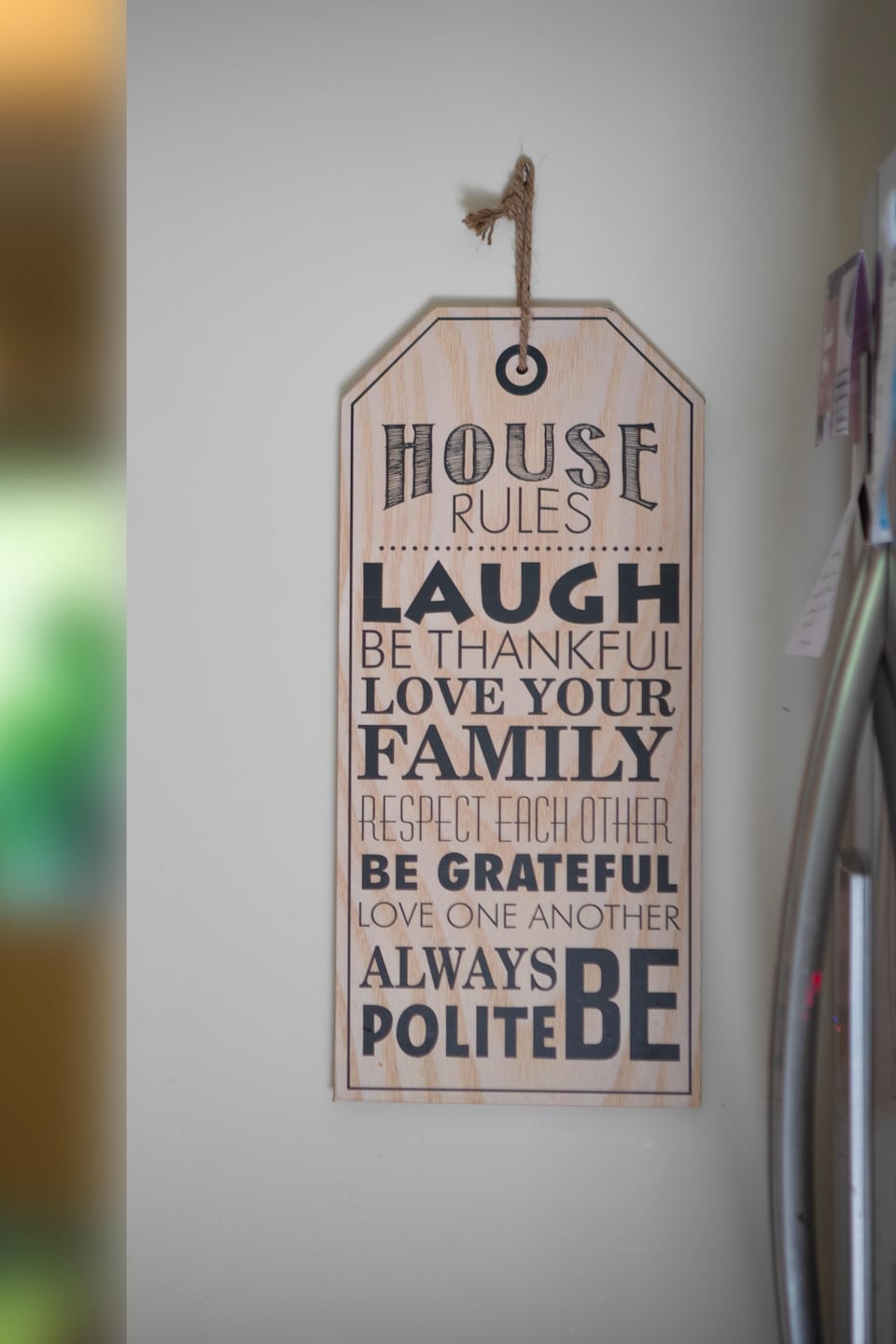 Une affiche décorative dans la cuisine de Mallory indiquant les règles de la maison : rire, aimer sa famille, respecter les autres, etc.