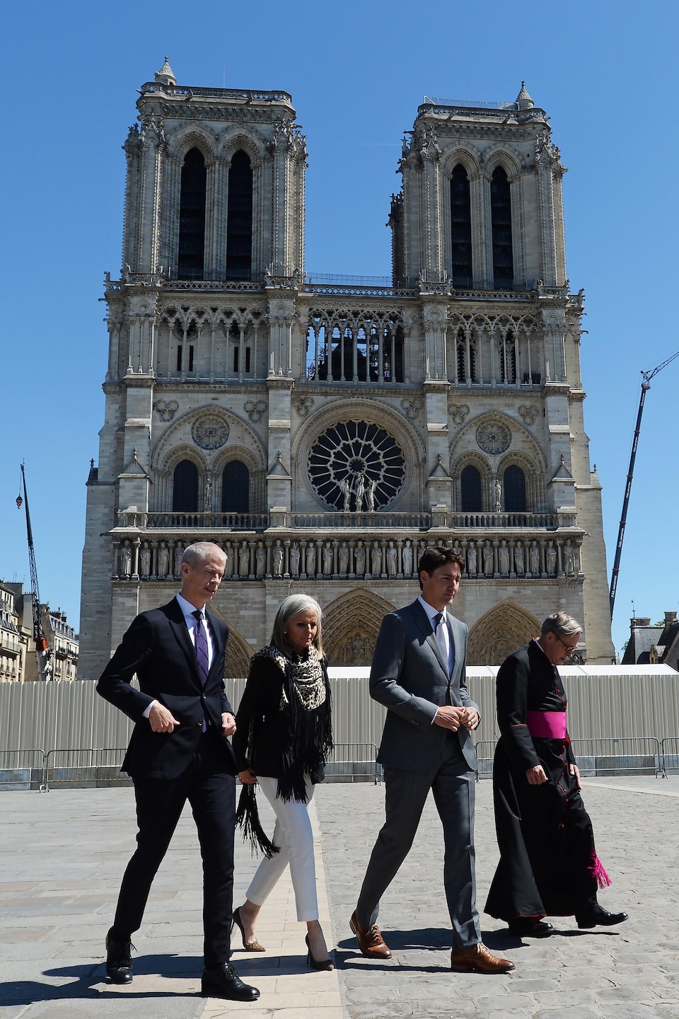 Justin Trudeau marche devant la cathédrale entourée d'une palissade.
