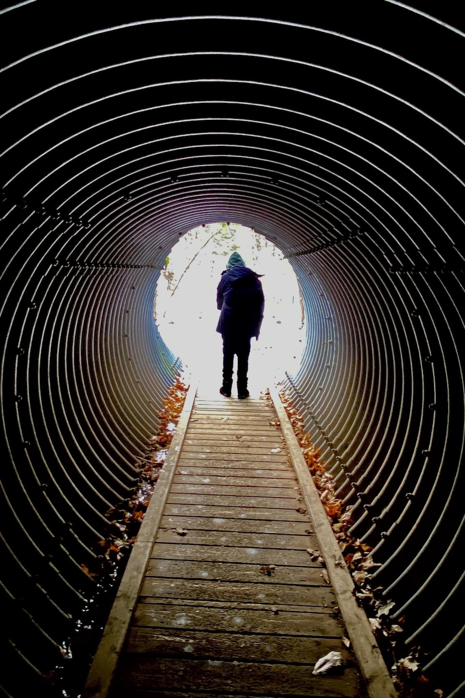 Un jeune garçon est au bout d’un tunnel piétonnier.