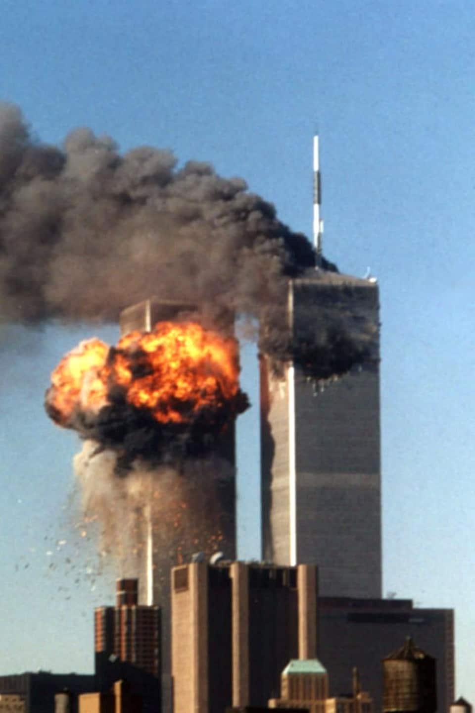 Une boule de feu s'échappe de la tour sud du World Trade Center, à New York, le 11 septembre 2001. Le vol 175 de United Airlines a percuté la tour à 9 h 03, heure de l'Est, soit un peu plus de 15 minutes après que le vol 11 d'American Airlines eut percuté la tour nord, de laquelle s'échappe toujours un panache de fumée.
