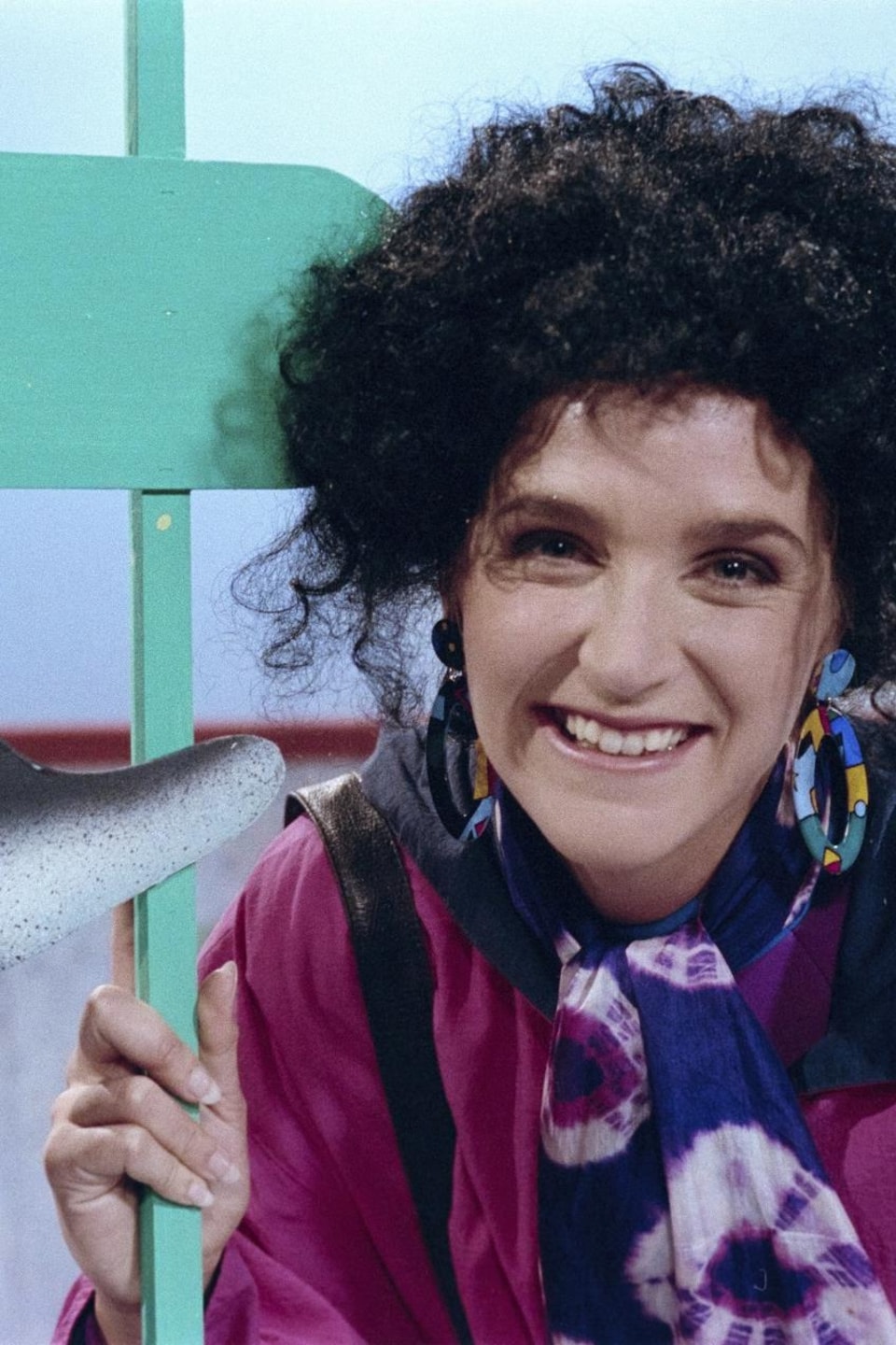 Sylvie Fréchette, souriante dans un décor d'aquarium avec un dauphin.