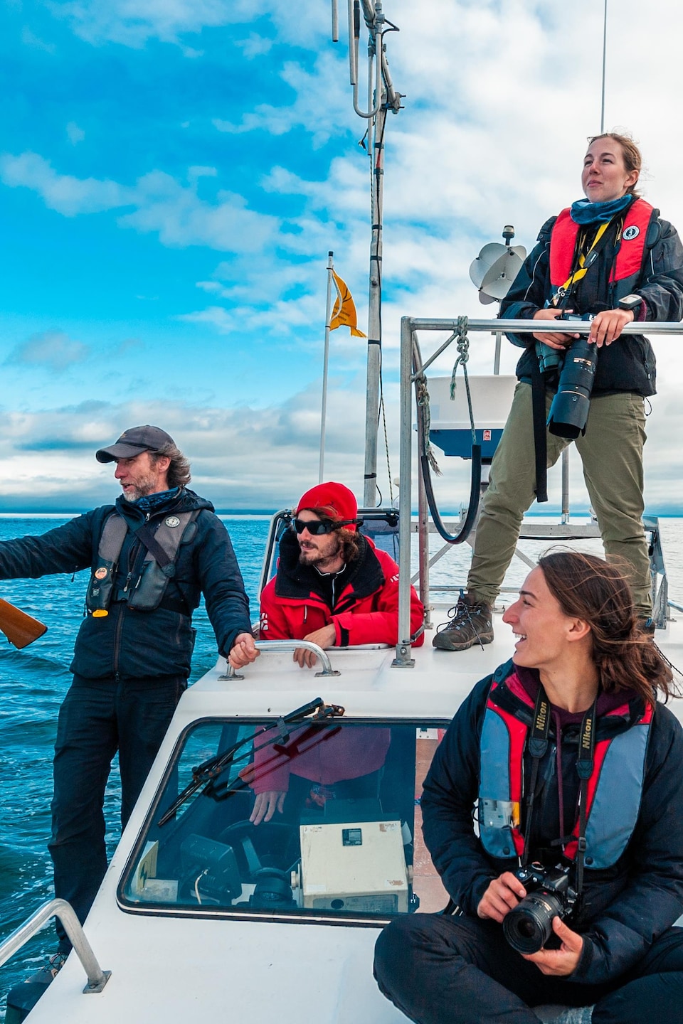 Des scientifiques (deux femmes et trois hommes) prennent place sur  un bateau à moteur de six places.