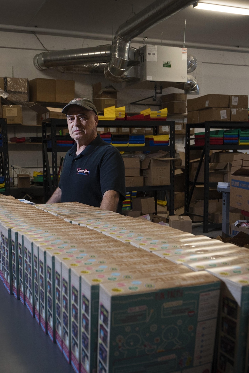 Mike Wiesel devant des boîtes dans un entrepôt.