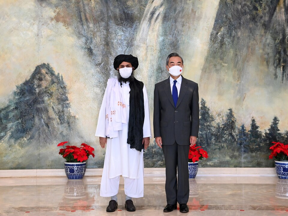 MM. Baradar et Wang portent des masques.