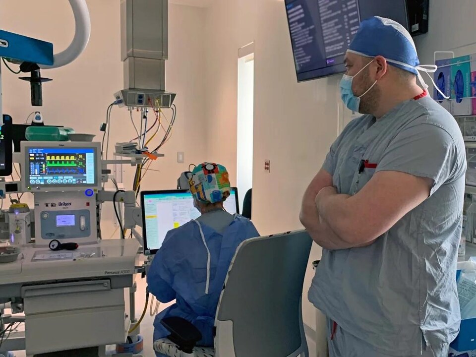 Le Dr Lafontaine se tient debout dans une salle d'opération d'un hôpital.