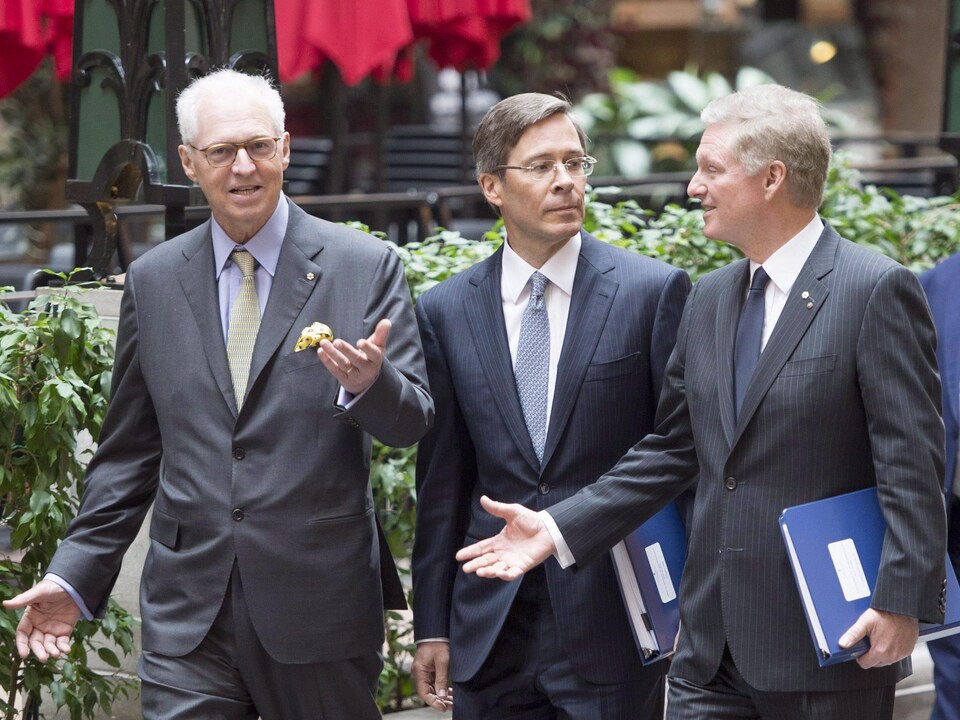 Les trois hommes marchent en discutant.