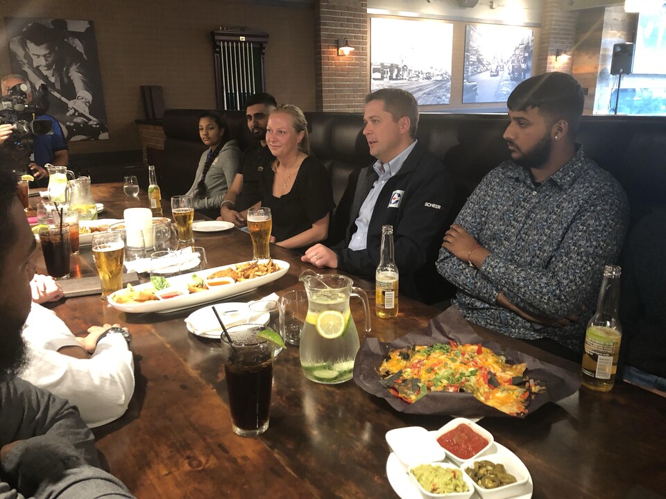 Andrew Scheer prend une bière avec des électeurs dans un bar d’Etobicoke.