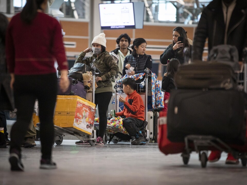 Des voyageurs avec leurs valises à l'aéroport