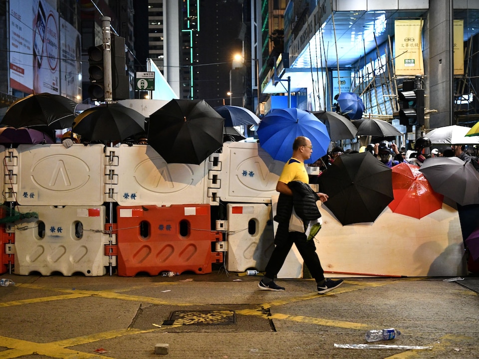 Une barricade de plastique et des parapluies.