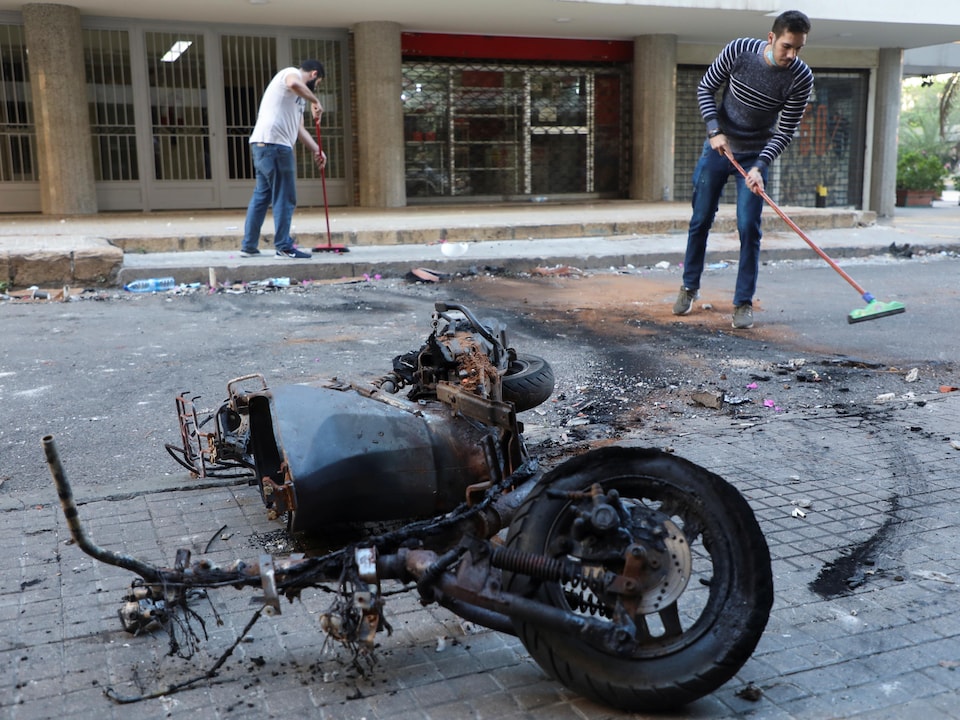 Two people wiped near the burnt motorcycle.