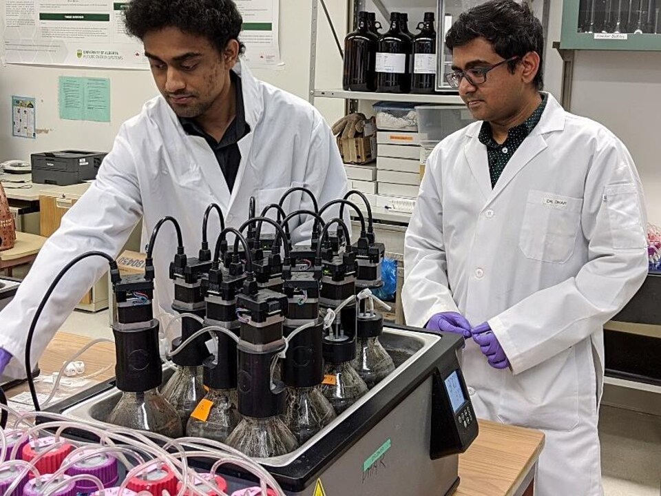 Deux chercheurs manipulent une machine dans un laboratoire universitaire.