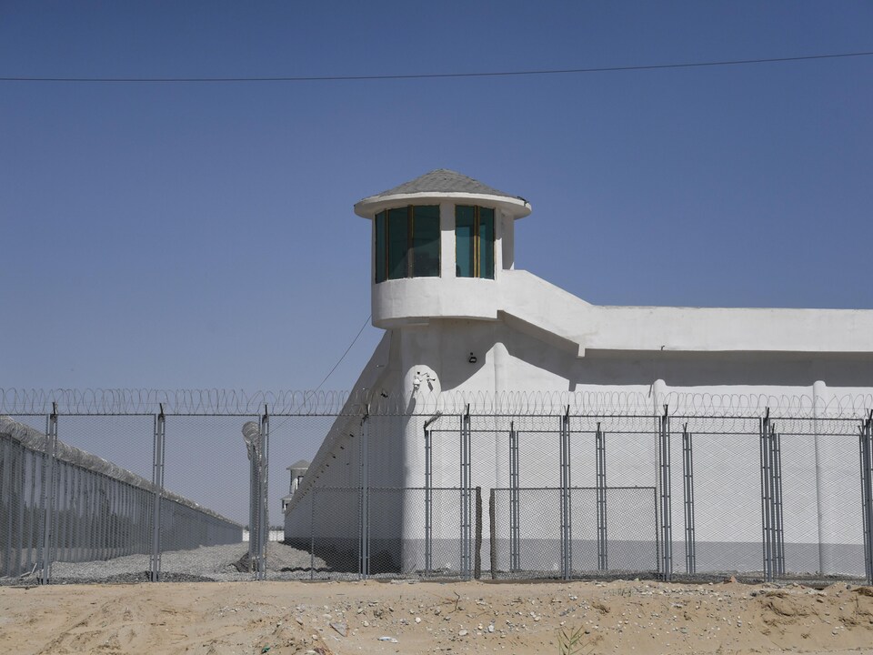 Una torre de vigilancia detrás de una cerca de alambre de púas.