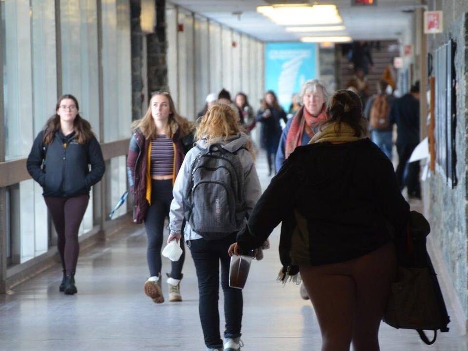 Des étudiants qui marchent dans un corridor. 