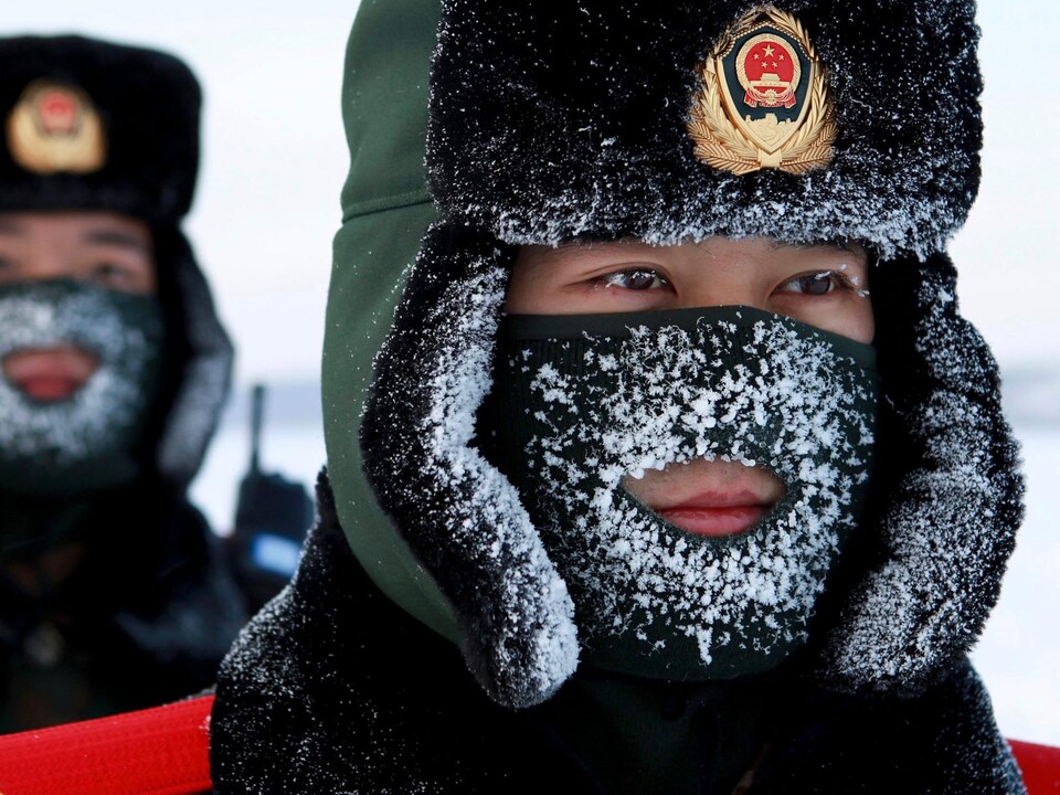 Les visages de deux gardes-frontières de la police paramilitaire chinoise qui s'entraînent dans la neige dans la province du Heilongjiang, à ​​proximité de la frontière russe.