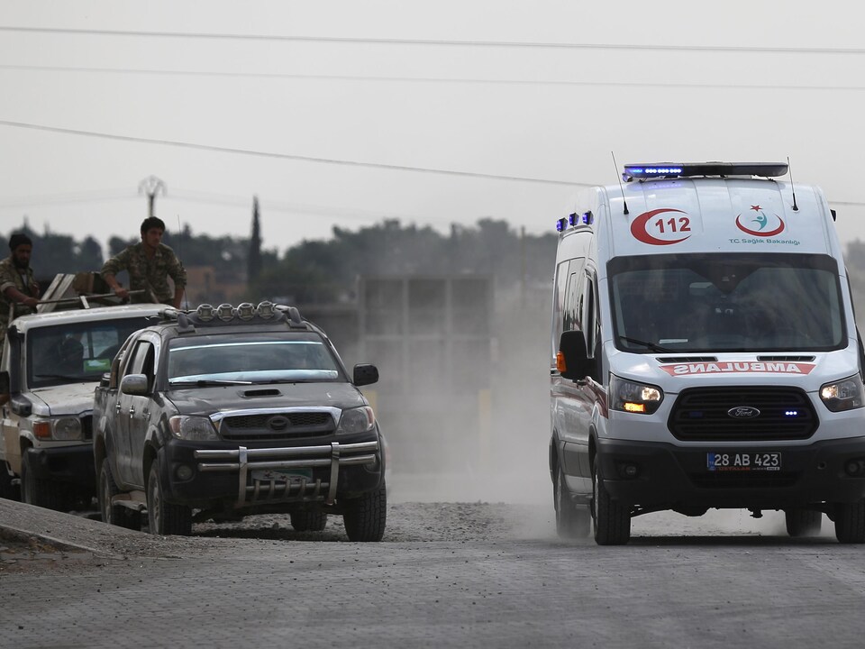 Une ambulance passe sous l'œil de rebelles syriens.